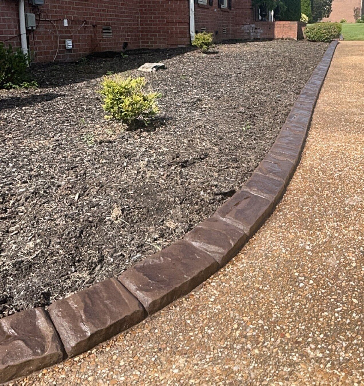 Brown stamped curbing along a mulch bed