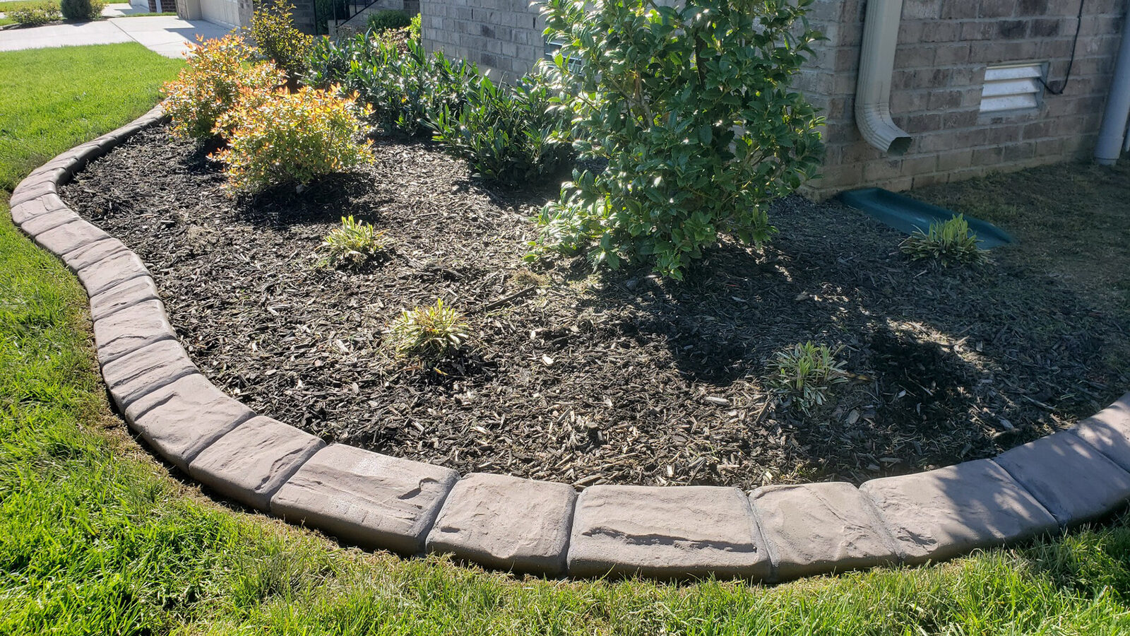 Finished curved curb along a mulch bed and a clean lawn edge