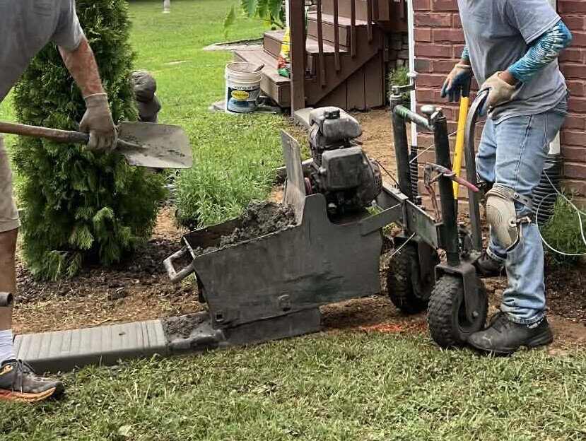 The curb machine extruding a continuous curb as the crew feeds it