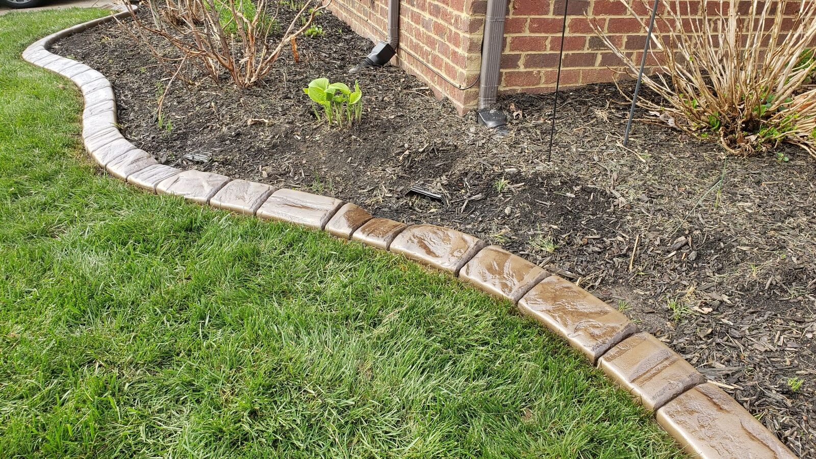 Tan stamped curbing following a curved foundation bed